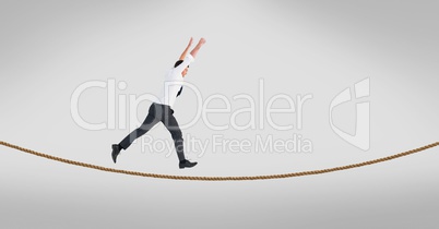 Businessman with arms raised walking on tightrope