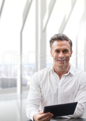 Happy business man at a desk using a tablet