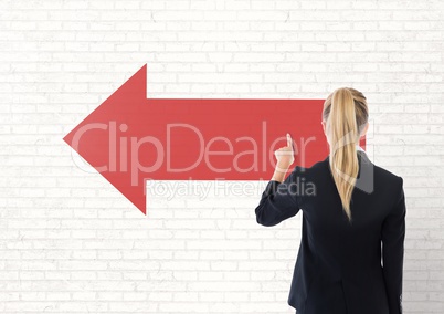 Business woman touching a red arrow against white wall