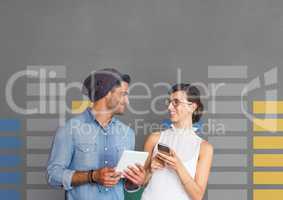 Happy business people holding a tablet and a phone against grey background with graphics