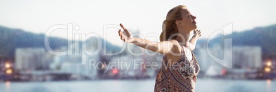Woman with arms out against blurry skyline