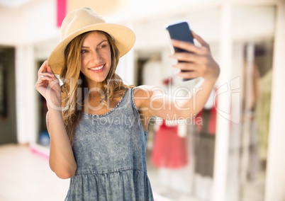 Woman taking casual selfie photo in front of shopping mall