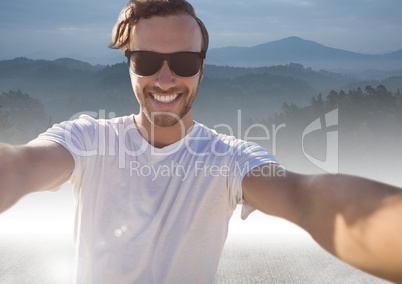Man taking casual selfie photo in front of mountain landscape