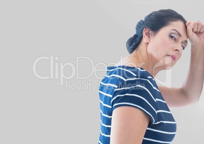 Portrait of woman leaning against wall with grey background