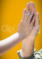 Close up of father and child high five against yellow background