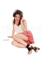 Woman sitting on floor listening to music.