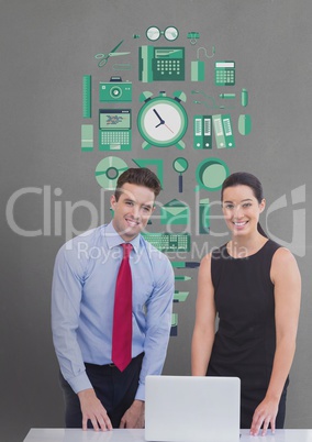 Happy business people at a desk using a computer against grey background with green graphic