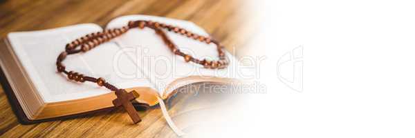 Rosary on bible and white transition