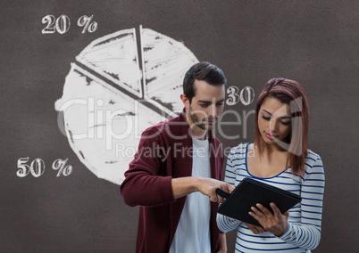 Business people using a tablet against brown background with graphics