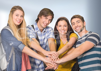 Students joing hands together in front of blurred background