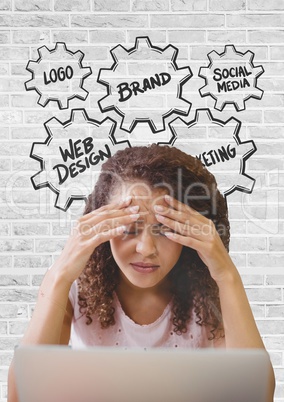 Frustrated business woman at a desk using a computer against white wall with graphics