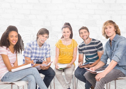 Group of students sitting in front of brick grey background