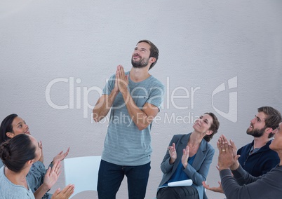 Group meeting sitting in circle in front of blank grey background