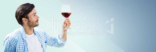 Man tasting wine against blue background