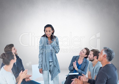 Group of business people sitting in circle meeting in front of blank grey background