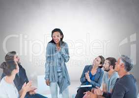 Group of business people sitting in circle meeting in front of blank grey background
