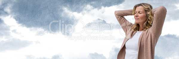 Middle aged woman relaxing against cloudy sky