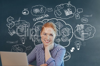 Happy business woman at a desk using a computer against blue background with graphics
