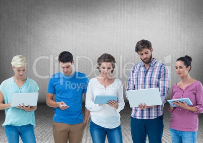 Group of friends standing in front of blank grey background with devices