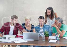 Group of people working at desk in front of grey background