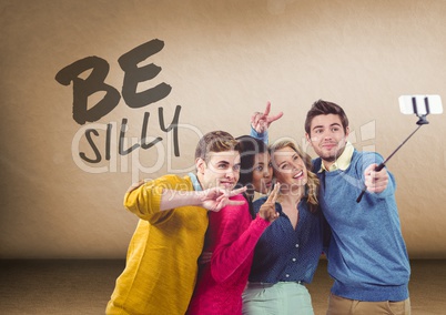 Group of people taking selfie in front of Be Silly text