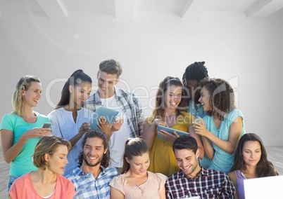 Group of people on devices in front of room