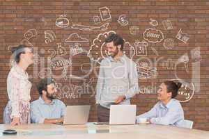 Business people at a desk talking against brick wall with graphics