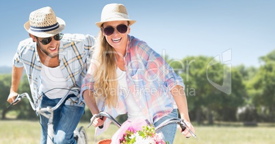 Couple on bicycles against blurry park