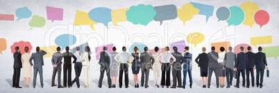 Group of business people standing in front of colorful chat bubbles