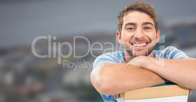 Student leaning on books in front of blurred background