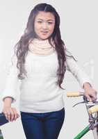 Portrait of woman holding bicycle with grey background