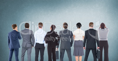 Group of business people standing in front of blank blue background