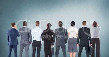 Group of business people standing in front of blank blue background