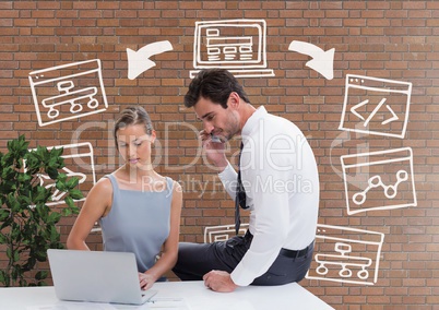 Business people at a desk looking at a computer against brick wall with graphics