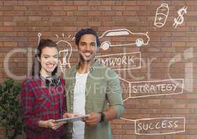 Happy business people holding a tablet against brick wall with graphics