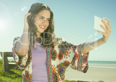 Woman taking casual selfie photo in front of seaside beach