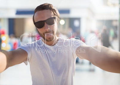 Man taking casual selfie photo in front of shopping mall