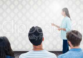 Group of people sitting in front of bright background with speaker