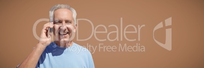 Elderly man on phone against brown background