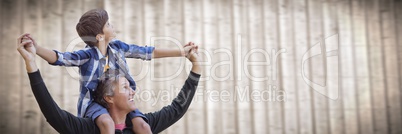 Father with son on shoulders against blurry wood panel