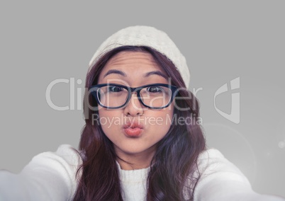 Portrait of woman blowing kisses with grey background