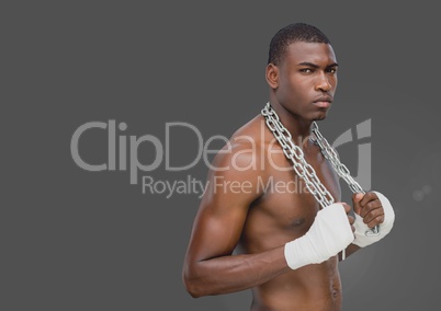 Portrait of strong muscular Man holding chains with grey background
