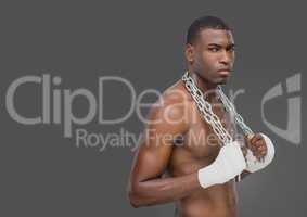 Portrait of strong muscular Man holding chains with grey background