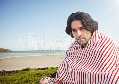 Man at the beach sitting in the grass