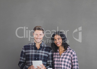Happy business people holding a tablet against grey background