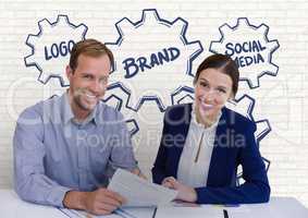 Happy business people at a desk holding a paper against white wall with graphics
