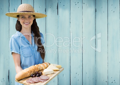 Woman with food platter against blue wood panel