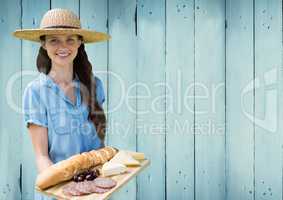 Woman with food platter against blue wood panel