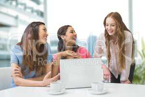 Happy business women at a desk using a computer