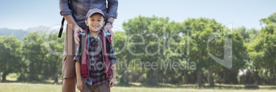 Father hands on son's shoulders against blurry trees
